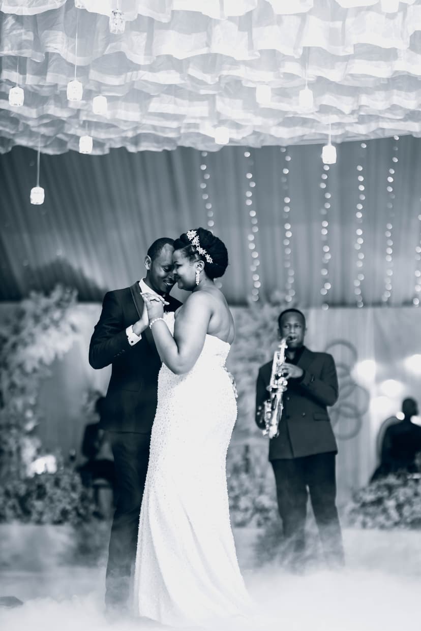 Black and white couple dancing at reception with saxophonist