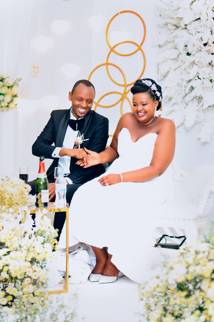 Couple laughing at reception table with flowers