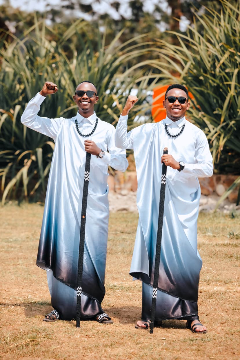 Grooms celebrating with raised fists in ceremonial dress