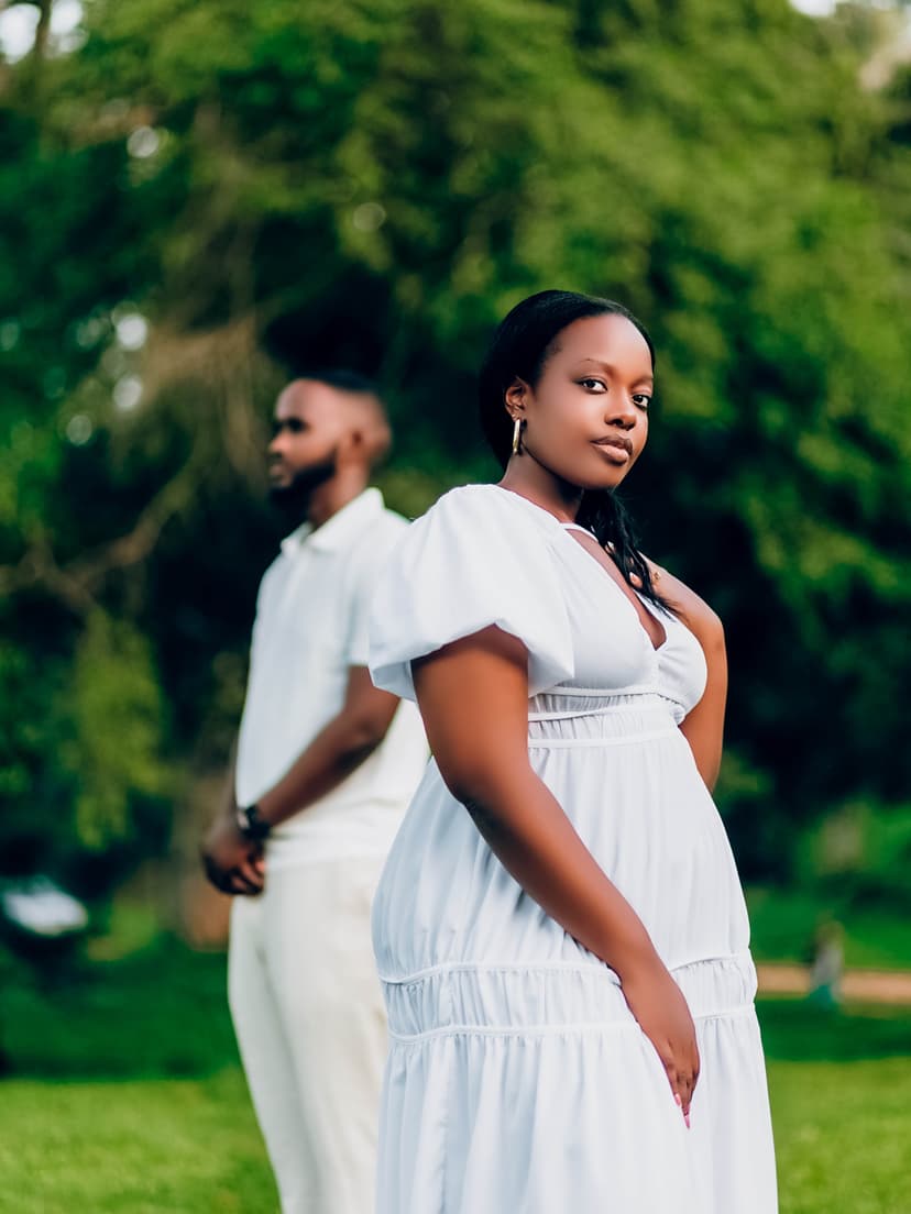 Pregnant couple in white dress in garden