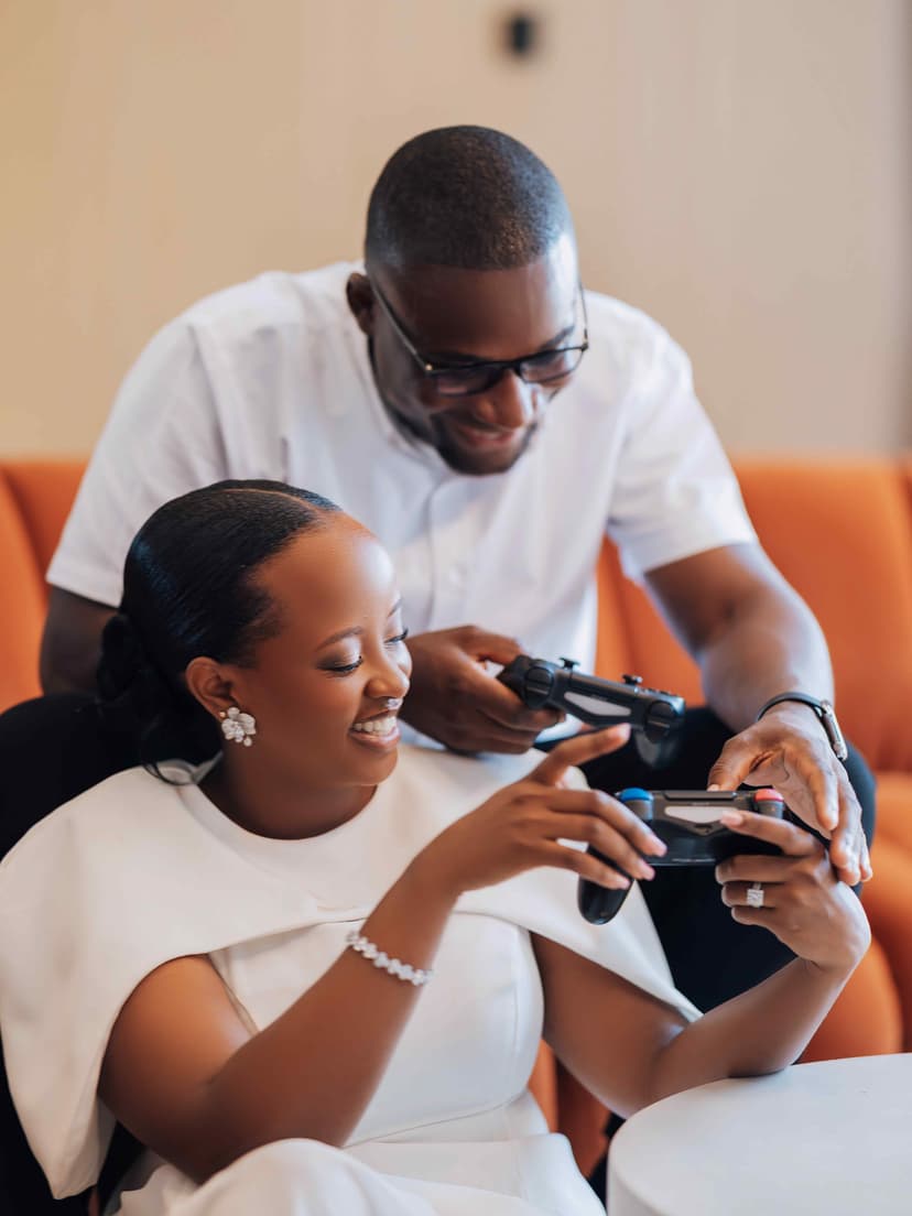 Couple with gaming controller on orange sofa