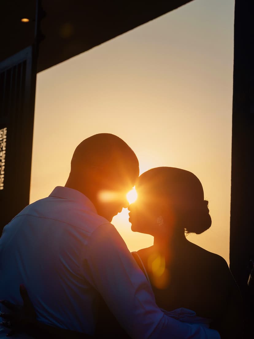 Silhouette couple kissing with golden sunset backdrop